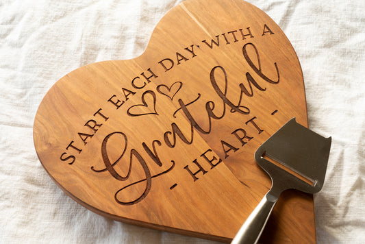 Heart shaped cutting board with "Start each day with a grateful heart" engraved.